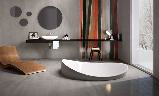 Modernes Badezimmer mit Fliesen der Serie Metal XXL von Iris Ceramica in Metalloptik, freistehender Badewanne und Holzliege.